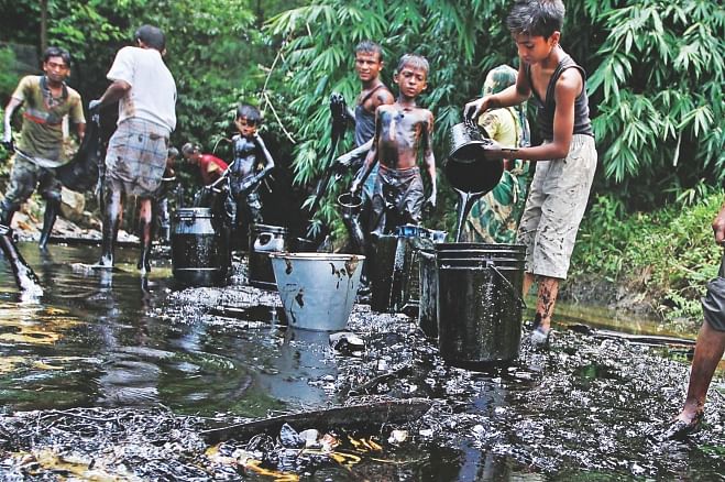 A train carrying furnace oil derails in Foujdarhat, Sitakunda in Chittagong spilling oil into a canal nearby. Locals scoop up the oil in their buckets to get some money by selling it. Photo: Anurup Kanti Das
