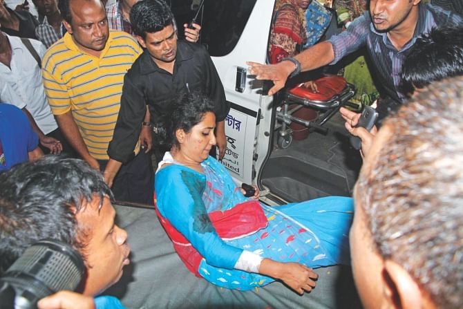 A wounded teacher being taken to Chittagong Medical College Hospital after alleged activists of Islami Chhatra Shibir exploded crude bombs in teachers' buses of Chittagong University yesterday.  Photo: Star