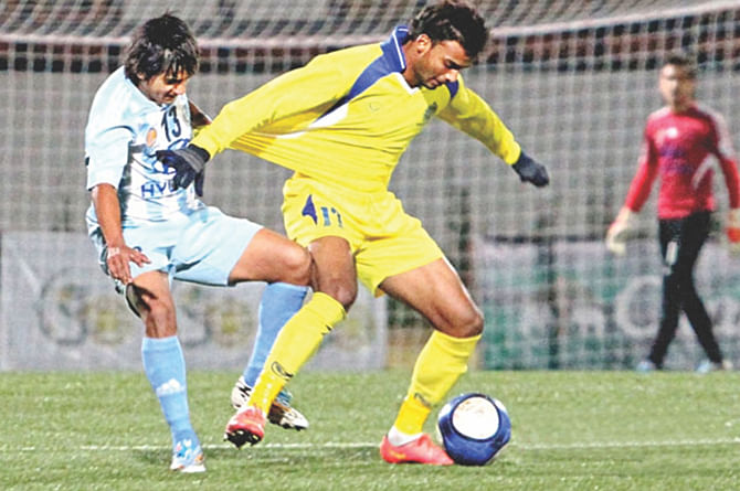 Abahani forward Aminur Rahman Sajib (R) has his shirt tugged from behind by a Manang Marshyangdi player during their King's Cup match yesterday. PHOTO: COURTESY