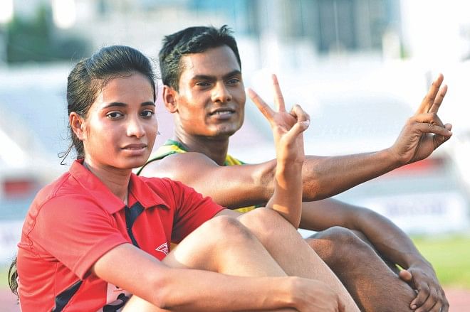 Abdullah Hasan and Tamanna Akter show victory signs after winning their respective 100m sprint finals in the Walton 30th National Junior Athletics Championships at the Bangabandhu National Stadium yesterday. PHOTO: STAR