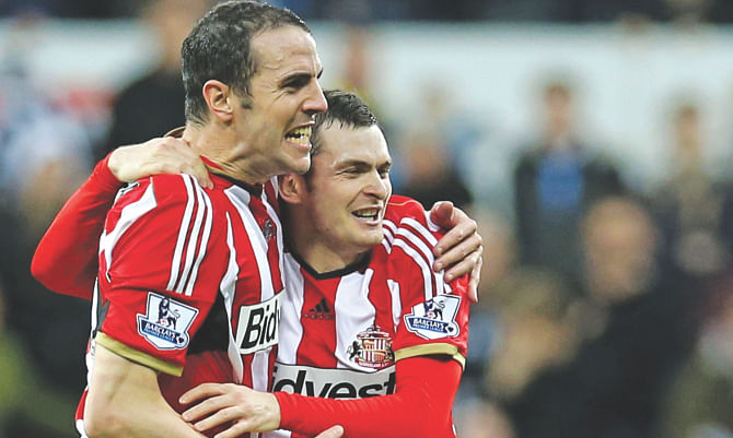 Sunderland midfielder Adam Johnson (R) celebrates his 89th minute winner with his teammate John O'Shea at St James's Park yesterday. Photo:  AFP