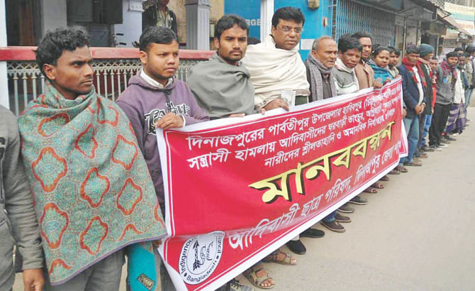 Adivasi Chhatra Parishad, Dinajpur district unit forms a human chain in front of Dinajpur Press Club yesterday demanding immediate arrest of those who attacked Santal people of Chirakutipara village in the district's Parbotipur upazila on Saturday. PStar