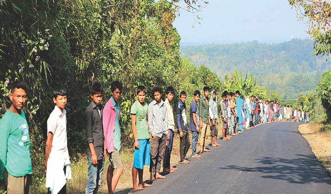 Adivasis of Suridaspara in Naniarchar upazila of Rangamati form a human chain yesterday protesting the Bangalee settlers' attack on them. Photo: Star