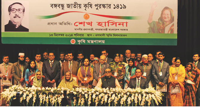 Recipients of Bangabandhu National Agriculture Award, standing behind, with Prime Minister Sheikh Hasina and guests in Osmani Memorial Auditorium of the capital yesterday. Thirty individuals and organisations got the award. Photo: BSS
