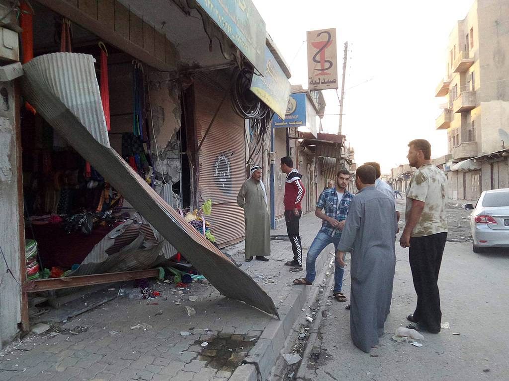 People inspect a shop damaged after what Isis militants say was a U.S. drone crashed into a communication station nearby in Raqqa Reuters