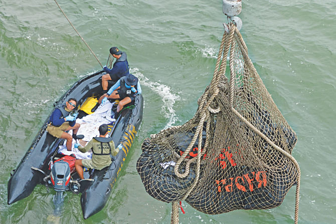 Bags containing dead bodies are lifted onboard Indonesian Navy vessel KRI Banda Aceh during search operations for AirAsia flight QZ8501 in the Java sea yesterday.  Photo: AFP