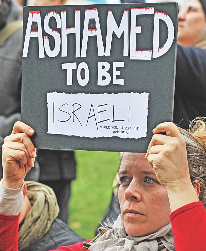 An Israeli protester holds a placard during a march organised in support of the Global Day of Rage against Israel's actions in Gaza in Melbourne, yesterday. Protest leaders called for an end to Israel's bombardment and blockade of Gaza, the Australian government to cut all economic, political and military ties with Israel. Similar protests also held in major cities of England, France, South Africa and many other nations. Photo: AFP