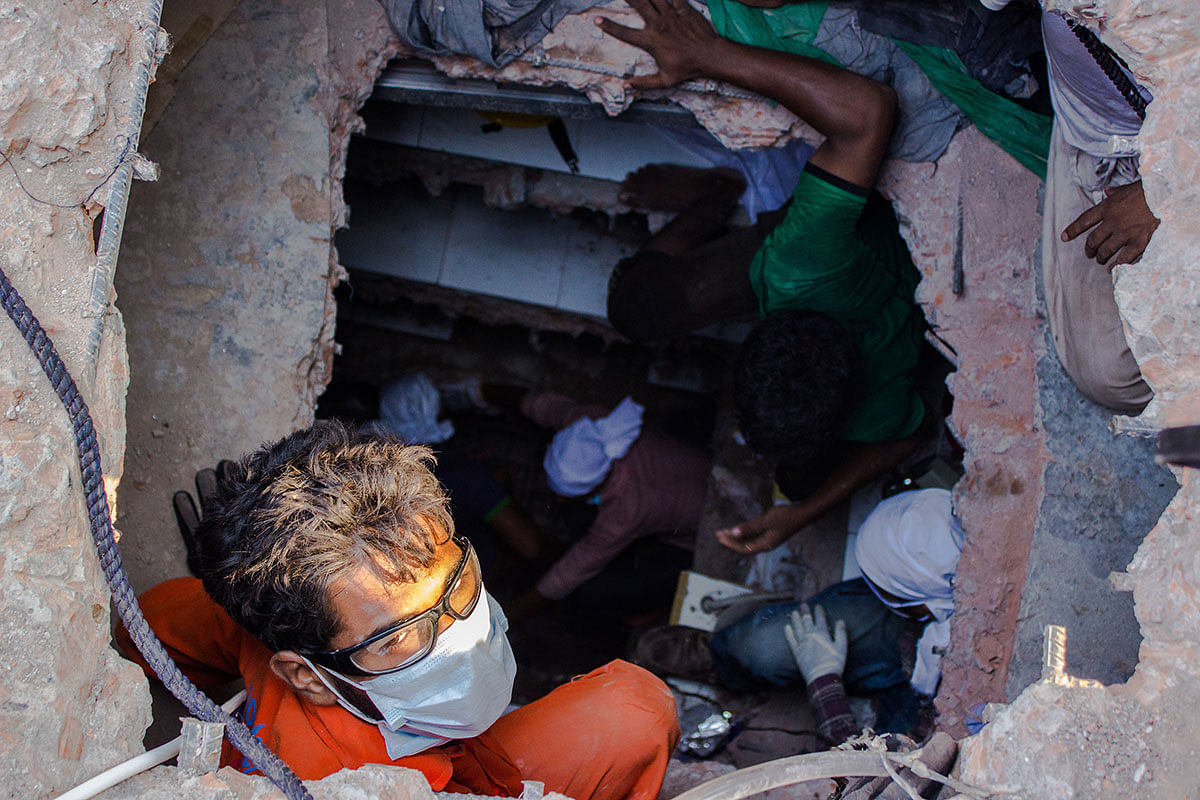 Volunteers go down through a dug tunnel in search of survivors. Photo: Anik Rahman