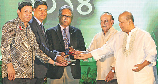 Prof Ainun Nishat, centre, holds the Prokriti O Jibon Foundation and Channel i “Nature Conservation Award 2014" at a ceremony in Channel i Bhaban in the capital yesterday. From left to right, Muqeed Majumdar Babu, director of Impress Telefilm Ltd/Channel i and also chairman of the foundation, Deputy Environment and Forests Minister Abdullah Al Islam Jakob, Environment and Forests Minister Anwar Hossain Manju, and Faridur Reza Sagar, managing director of Impress Telefilm Ltd/Channel i, were also present. Photo: Star