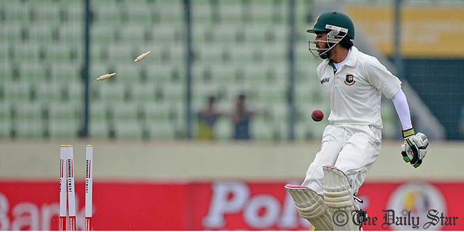 Bangladesh top-order Mominul Haque stares at the broken stumps, after he is run out during first Test against Zimbabwe at Mirpur stadium on Sunday. Photo: Firoz Ahmed