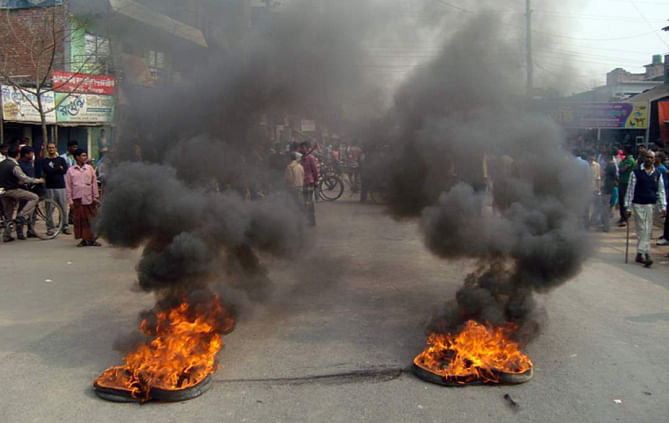 Protesters block Dianjpur-Dhaka highway by burning tyres in Nimtola area under Phulbari municipality. Photo: Star