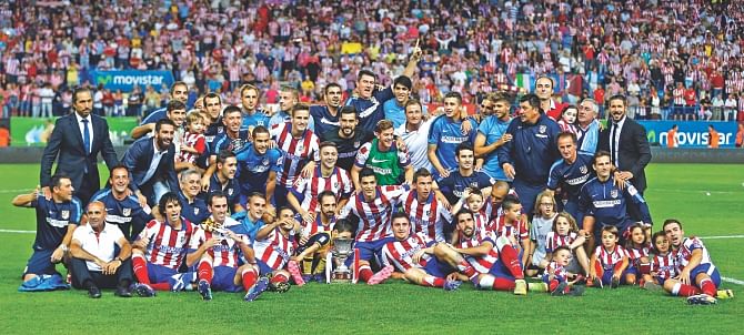 Atletico Madrid players celebrate with the Spanish Super Cup trophy after winning the second leg match against Real Madrid at the Vicente Calderon on Friday. Photo: Reuters