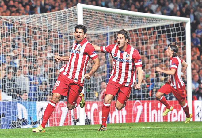 Atletico Madrid forward Diego Costa (L) celebrates with teammate Koke (C) after scoring his team's second goal from a penalty during their 3-1 win over Chelsea in the Champions League semifinal second leg match at Stamford Bridge in London yesterday. PHOTO: AFP