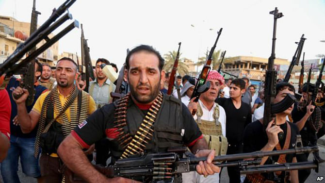 Iraqi Shia tribal fighters deploy with their weapons while chanting slogans against the al-Qaeda-inspired Islamic State of Iraq and the Levant, in Baghdad's Sadr City, Iraq, June 13.