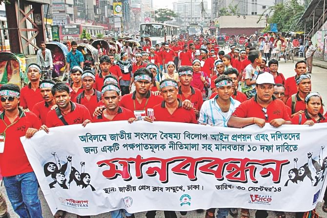 Bangladesh Dalit Parishad brings out a procession before Jatiya Press Club in the capital yesterday demanding that the government enact the proposed Antidiscrimination Act soon and ensure the rights of the community. Photo: Star