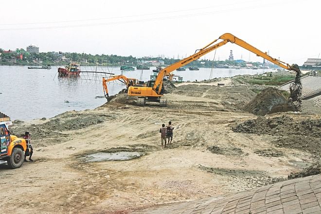Bangladesh Inland Water Authority (BIWTA) removes earth, which has been dumped by grabbers encroaching upon the Shitalakkhya near Kanchpur bridge yesterday. The earth-filling was carried out by the people allegedly backed by Narayanganj city councillor Nur Hossain, also the prime accused of a recent seven-murder.Photo: Sk Enamul Haq