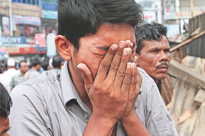 Son of the shop owner failing to hold back tears. Photo:Anisur Rahman