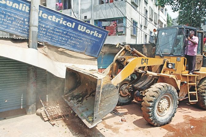 Bangladesh Railway destroying illegal structures built beside rail lines in Moghbazar area yesterday. The move comes after four people got killed by a train at an illegal fish market set up on the train lines in Karwan Bazar on Thursday. Photo: Palash Khan