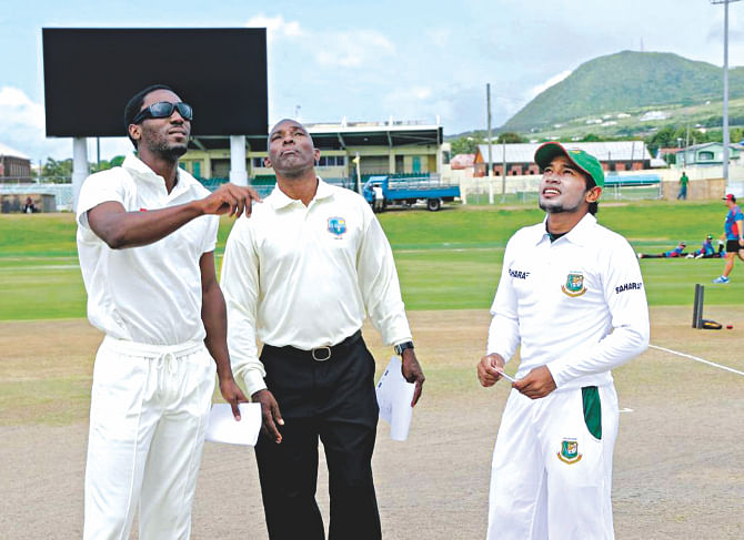 Bangladesh captain Mushfiqur Rahim and his counterpart Jacques Taylor wait for the coin to hit the ground at the toss before the three-day practice match between the Tigers and St Kitts and Nevis. Bangladesh won the toss and elected to bat.   Photo: WICB 