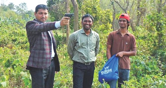 Matiar Rahman, left, a teacher of statistics at Jagannath University, aiming a pistol during a 