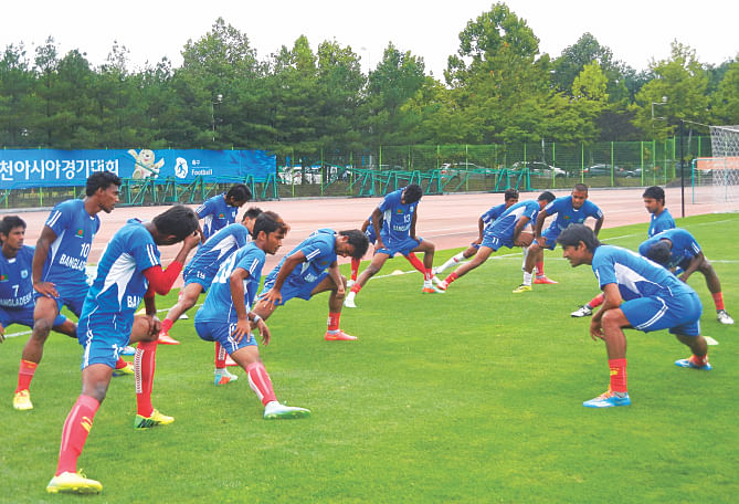 Bangladesh players stretch at the Goyang ground in Incheon yesterday, ahead of their do-or-die battle against Hong Kong today. PHOTO: ANISUR RAHMAN