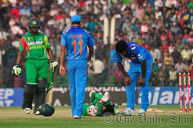 Indian pacer Varun Aaron apologises to Bangladesh skipper Mushfiqur Rahim as an enraged beamer hit the batsman's ribcage during an Asia Cup 2014 match in Fatullah today. Photo: Firoz Ahmed
