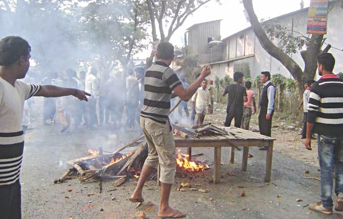 Locals burn furniture and wood on Dhaka-Dinajpur highway to block it at Phulbari.  Photo: Star