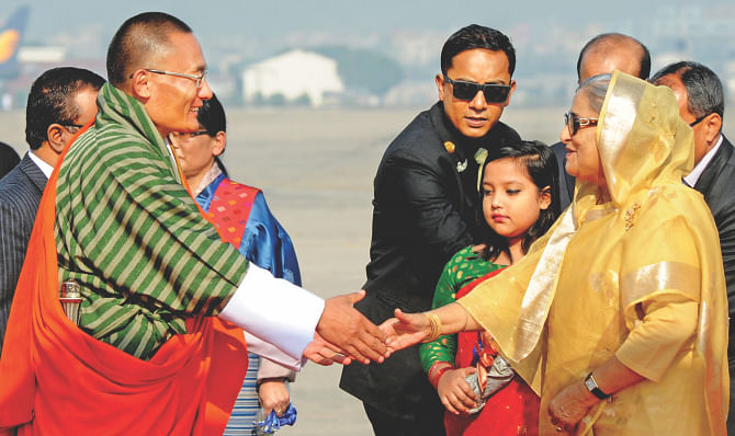Prime Minister Sheikh Hasina welcomes her Bhutanese counterpart Tshering Tobgay at Hazrat Shahjalal International Airport yesterday. Photo: BSS