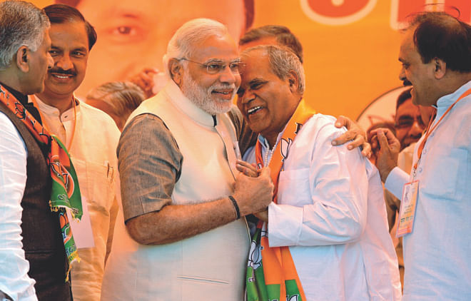 BJP prime ministerial candidate Narendra Modi (3L) greets Ramesh (2R), a former Congress Party member who joined the BJP, during a election rally in Ghaziabad.
