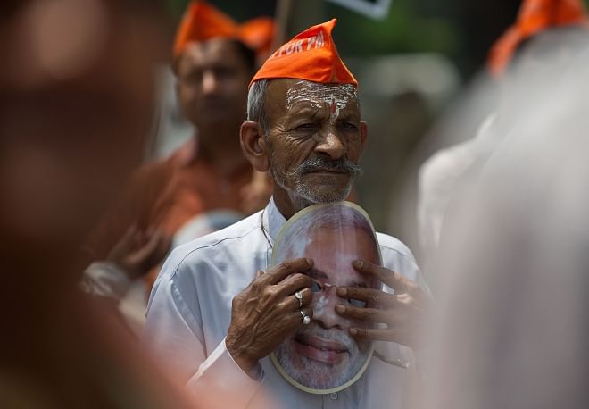 A BJP supporter listens to a speech during a protest against the Election Commission (EC) in New Delhi, yesterday. BJP workers protested against the denial of permission for BJP prime ministerial candidate Narendra Modi to hold a rally at a venue of his choice in Varanasi and requested the EC to remove the Electoral Officer of Varanasi.  Photo: AFP