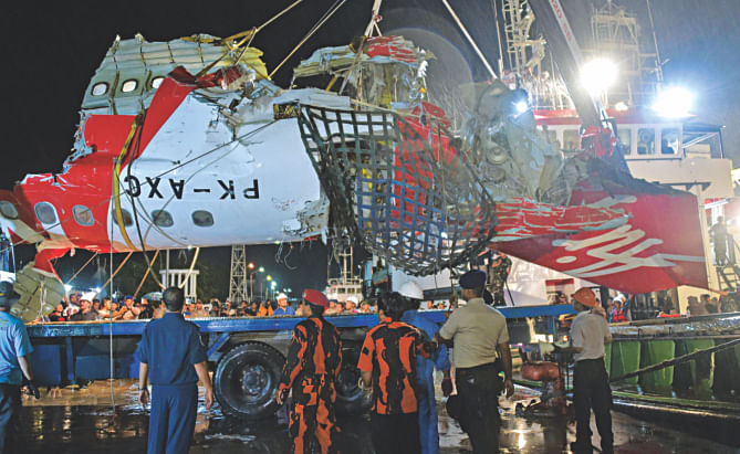 Indonesian personnel unload a section of recovered wreckage belonging to AirAsia flight QZ8501 onto a truck at port in Kumai, yesterday.  Photo: AFP
