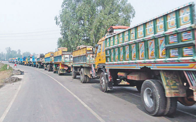 Trucks lie stranded in a kilometres-long queue on the road leading to Barapukuria coal mine in Dinajpur yesterday as vehicular movement got badly disturbed due to hartal in the district and countrywide blockade enforced by BNP-led 20-party alliance. PHOTO: STAR