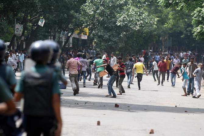 BNP leaders and activists hurl brick chunks to law enforcers during a clash in Bakshibazar area of Dhaka on Wednesday. They lock into a clash with police after BNP Chairperson Khaleda Zia appeared before a court in Dhaka in connection with Zia Orphanage and Zia Charitable Trust graft cases. Photo: STAR