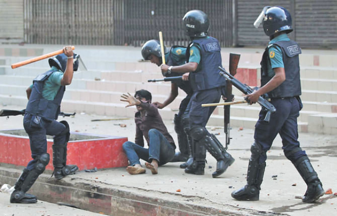 Police charge batons on an injured BNP man left behind during the clash. Photo: Anurup Kanti Das