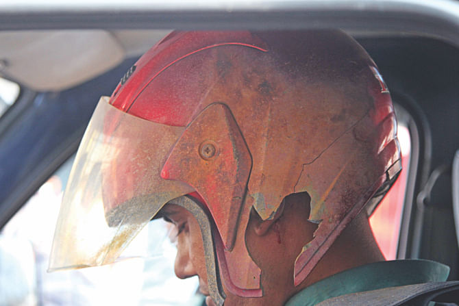 A policeman, with his helmet partly damaged in a homemade bomb attack in Motijheel, being taken to hospital. Photo: Star