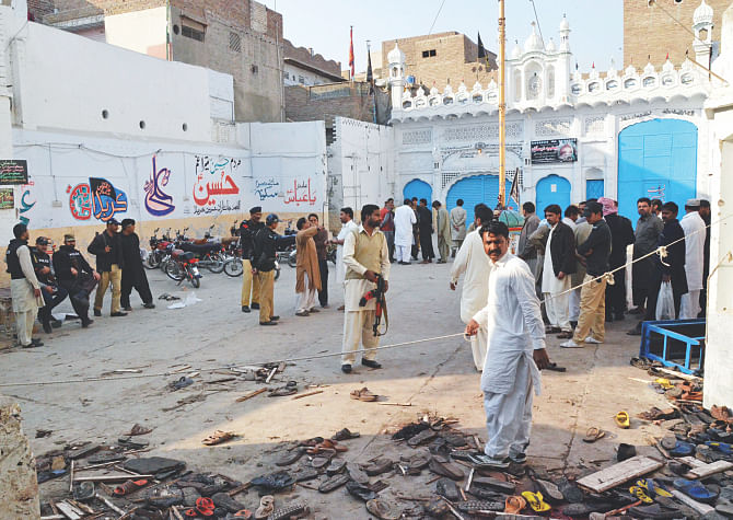 Pakistani security officials gather at the scene following a bomb attack at a Shiite Muslim mosque in Shikarpur in Sindh province, some 470 kilometres north of Karachi yesterday. A bomb tore through a busy Shiite mosque in southern Pakistan killing at least 20 people, officials said, in the deadliest sectarian attack to hit the country in a year. Photo: AFP