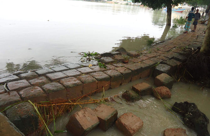 Patuakhali town was flooded again as tidal water entered it through breaches at different points of the dyke yesterday. Photo shows water overflowing the embankment in Katpatty area. PHOTO: STAR