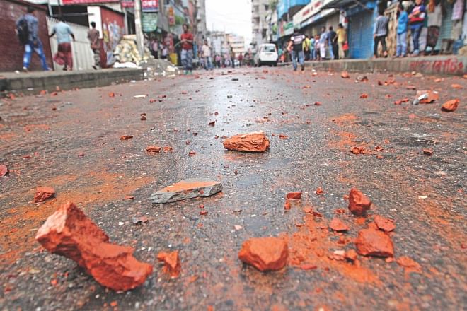 Brick chunks lay on a street in Mirpur-11 in the capital yesterday afternoon after a group of Biharis go on the rampage demanding punishment for the people who burnt nine Biharis alive in their home at Kurmitola Saturday morning.  Photo: Palash Khan