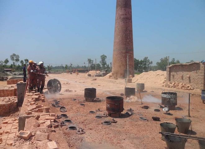Fire Service men douse the fire of this illegal brick kiln in Badarganj upazila under Rangpur district yesterday as the High Court ordered its closure.  PHOTO: STAR