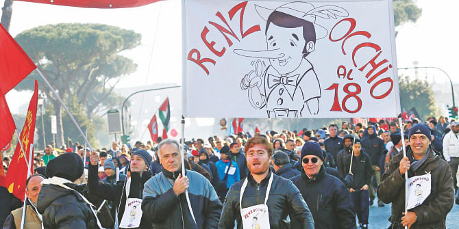 Protesters hold a banner depicting the puppet Pinocchio with the face of Italian Prime Minister Matteo Renzi and reading "Renzi pay attention to the clause 18" during a demonstration against government in downtown Rome on December 12. Photo: Reuters/File
