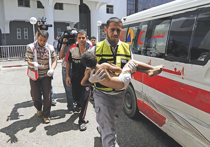 An emergency worker carries a child, wounded in an Israeli air strike on the Sheikh Radwan neighbourhood in Gaza, at the city's Al-Shifa hospital yesterday. Israeli warplanes struck targets across Gaza in retaliation to rocket fire after a 72-hour truce expired. Photo: AFP
