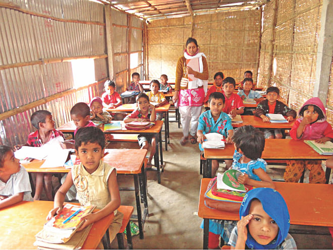 The lone teacher of the lone school in Thakur Palsha village imparting lessons in a classroom of the Sonamoni Pathshala. Tea vendor Rafiqul Islam Bhola, who cannot read or write, built the school for the children of his village. Photo: Star