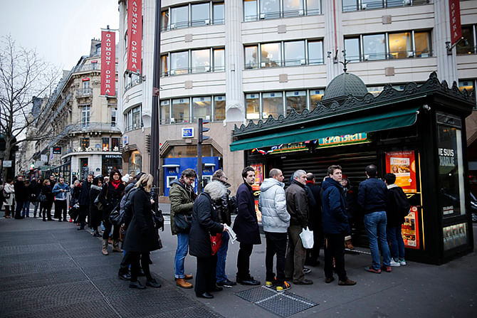 People queue to get a copy of satirical French magazine Charlie Hebdo new issue titled 