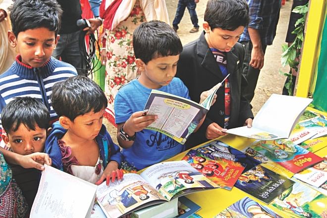 Children browse through books at a stall of Amar Ekushey Boi Mela on the Bangla Academy premises yesterday.  Photo: Palash Khan