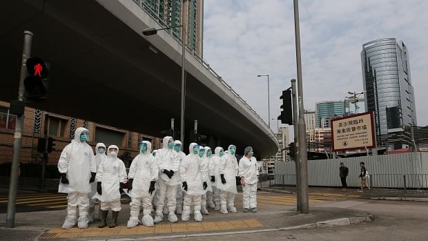 Caption: Health workers in full protective wait to get in a wholesale poultry market before culling the poultry in Hong Kong, January 28. Photo: AP