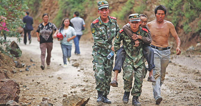 Rescuers carry an injured resident at Ludian county in Zhaotong. Photo: Reuters/AFP