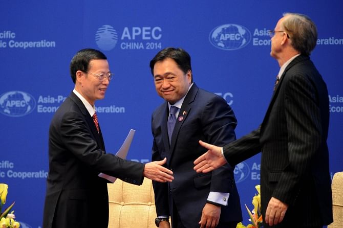 Left, Chinese Vice Premier Zhang Gaoli prepares to shake hands with APEC Secretariat Alan Esmond Bollard during the opening ceremony of the Asia-Pacific Economic Cooperation Finance Ministers' Meeting in Beijing yesterday. Photo: AFP