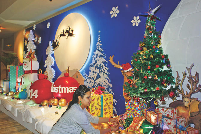 A woman gives last-minute touches to Christmas decorations at Pan Pacific Sonargaon Hotel in Dhaka.  Photo: RASHED SHUMON