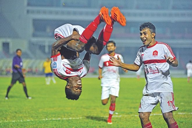Nigerian striker Chuka Charles of Feni Soccer Club celebrates scoring one of his two goals with a somersault in their Bangladesh Premier League match against Team BJMC yesterday at the Bangabandhu National Stadium. Photo: Firoz Ahmed