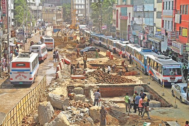 Outer Circular Road near Moghbazar used to have three lanes on either side. But because of the ongoing construction work of Moghbazar-Mouchak flyover, it has become a single-lane street, which too is potholed.  Photo: Amran Hossain